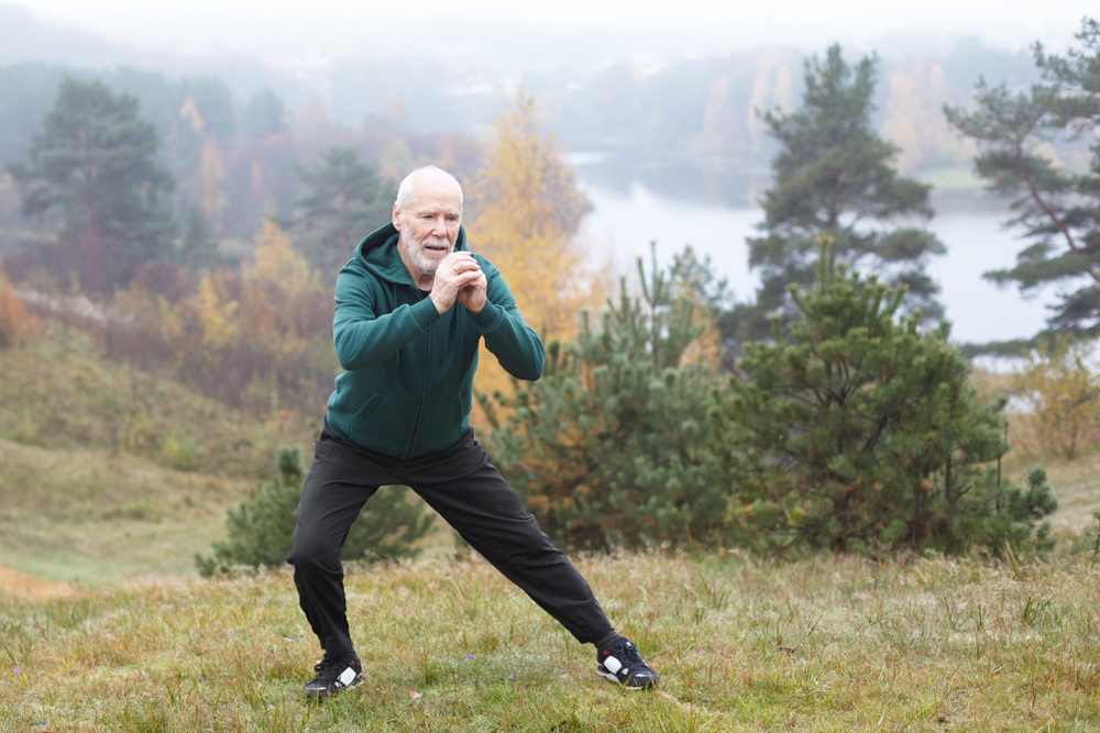 Older adult practicing balance exercise outdoors.