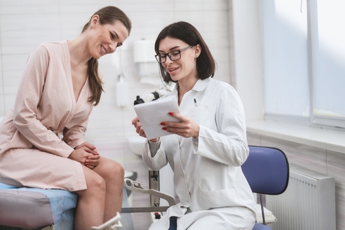 Healthcare provider reviewing notes with a patient on a tablet.